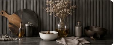Dark elegant kitchen counter with cookware, wood board, bowls, and glass bottles